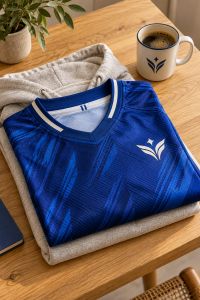 Maglia da calcio personalizzata piegata accanto a felpa e tazza